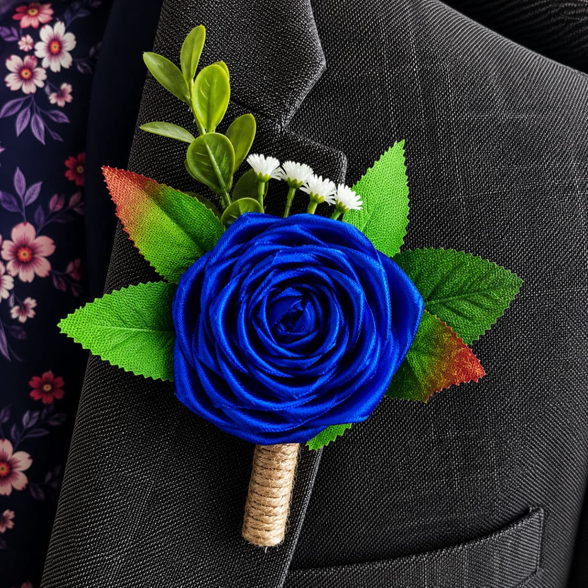 Royal Blue satin rose buttonhole attached to a formal grey suit jacket lapel